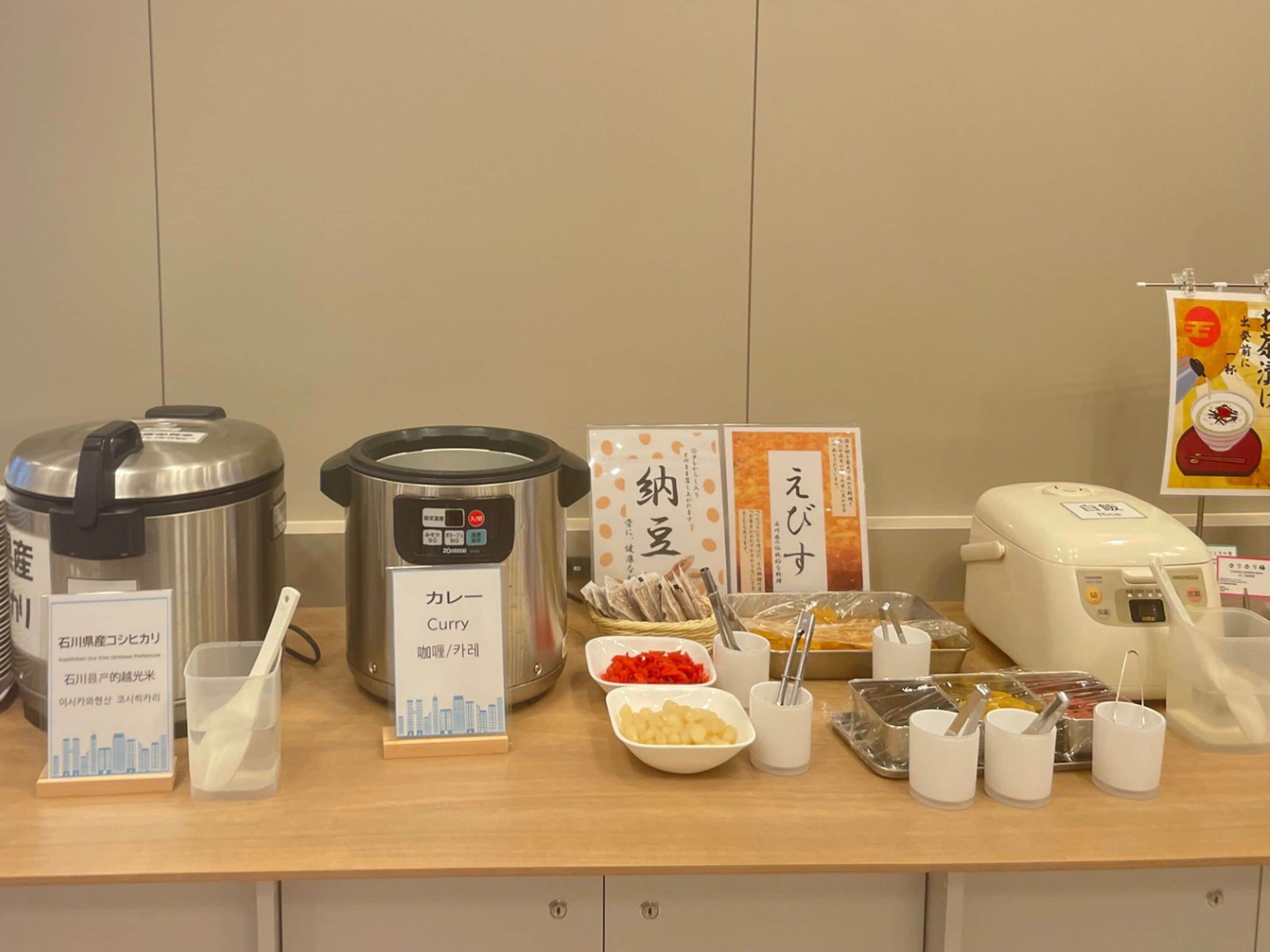 A buffet setup with various food items and cooking appliances.