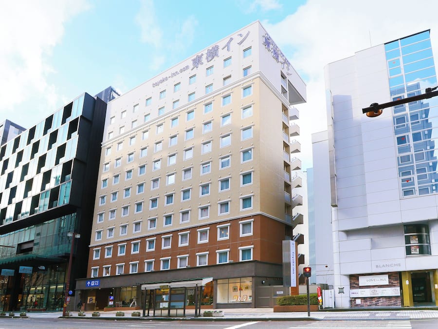 A multi-story hotel with a modern design, featuring a mix of glass and brick facades.