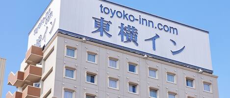 Un edificio con un letrero que dice "toyoko-inn.com" y caracteres japoneses.