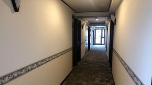 A hotel hallway with carpeted floors, patterned wall borders, and doors leading to rooms. - Toyoko Inn Tokyo Ueno Tawaramachi-eki (Tokyo)