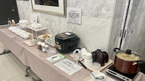 A buffet setup with various food items and condiments on a table, a rice cooker, and a pot on a portable stove. - Toyoko Inn Tokyo Ueno Tawaramachi-eki (Tokyo)
