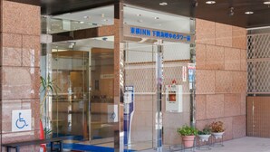 A hotel entrance with a glass door, a wheelchair accessibility sign, and a fire extinguisher. - Toyoko Inn Shimonos Station Kaikyo Yume Tower Mae (Shimonoseki)