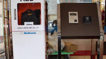 An AED device with a Medtronic logo, a small box, and a white dog under a table.