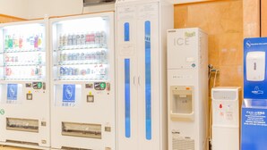 Une rangée de distributeurs automatiques et un point d’eau dans le hall d’un hôtel.
