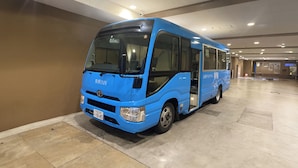 A blue bus parked in a spacious indoor parking area with a tiled floor and a high ceiling. - Toyoko Inn Tokyo Station Shin Ohashi Mae (Tokyo)