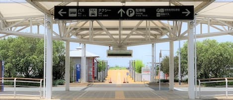 A bus station with directional signs for bus, taxi, and parking.