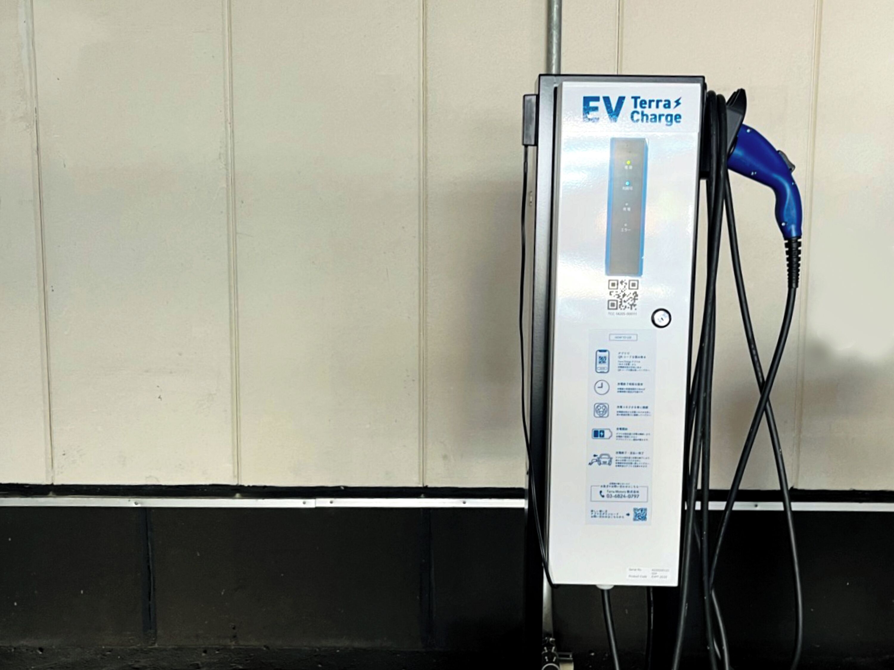 Een EV Terra laadstation met een oplaadkabel aangesloten op een blauwe stekker.