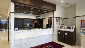 A hotel reception area with a marble counter, a digital screen, and self-service kiosks. - Toyoko Inn Tochigi Ashikaga Station Kita (Ashikaga)