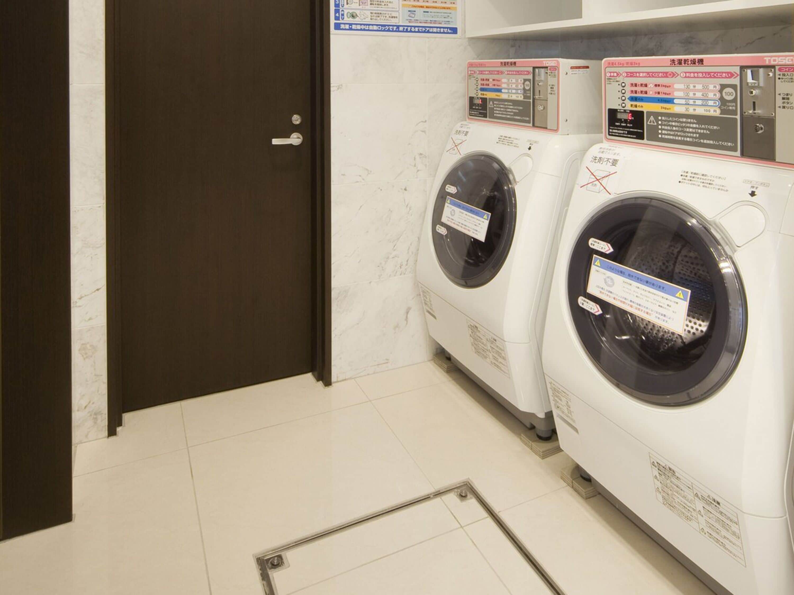 A laundry room with two washing machines and a door.