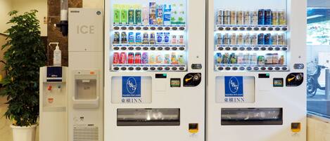Dos máquinas expendedoras con diversas bebidas y un dispensador de agua.