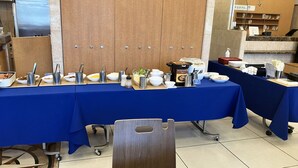 A buffet setup with various food items and condiments on a blue tablecloth. - Toyoko Inn Kiryu Station Minami (Kiryu)