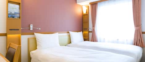 A hotel room with two beds, a desk, and a window with curtains.