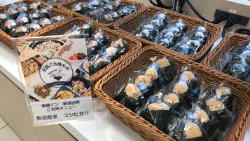 Cesti di vimini pieni di alimenti confezionati, un cartello con testo giapponese e una presa di corrente sullo sfondo.