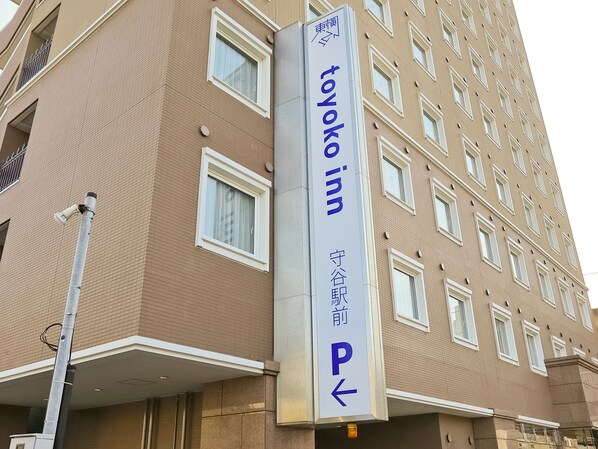 Een bord voor hotel Tokyo Inn met een pijltje dat naar links wijst.