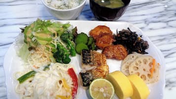 A plate of food including noodles, vegetables, fish, and tofu.