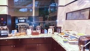 A kitchen area with a coffee machine, microwave, and various food items on the counter. - Toyoko Inn Tokushima Ekimae (Tokushima)