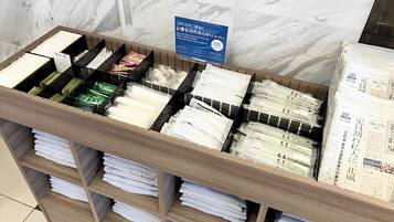 Una exhibición de toallas y ropa de cama dobladas cuidadosamente en un estante de madera, con un cartel que anuncia una oferta promocional.