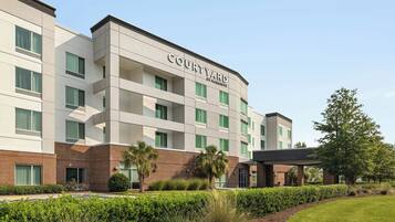 A Courtyard by Marriott hotel with a modern design, featuring a brick facade and multiple balconies.