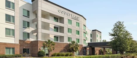 A Courtyard by Marriott hotel with a modern design, featuring a brick facade and multiple balconies.