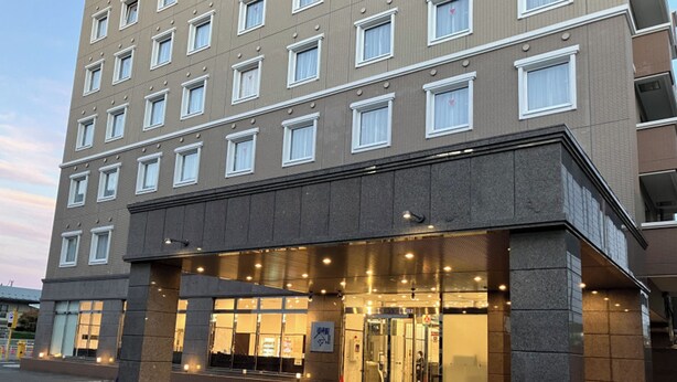 A multi-story hotel with a modern facade, large glass entrance, and a well-lit lobby area. - Toyoko Inn Kitakami Station Shinkan Line (Kitakami)