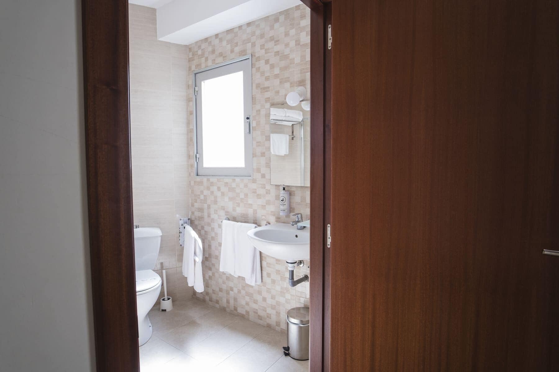 Un bagno moderno con il water, un lavandino e uno specchio.