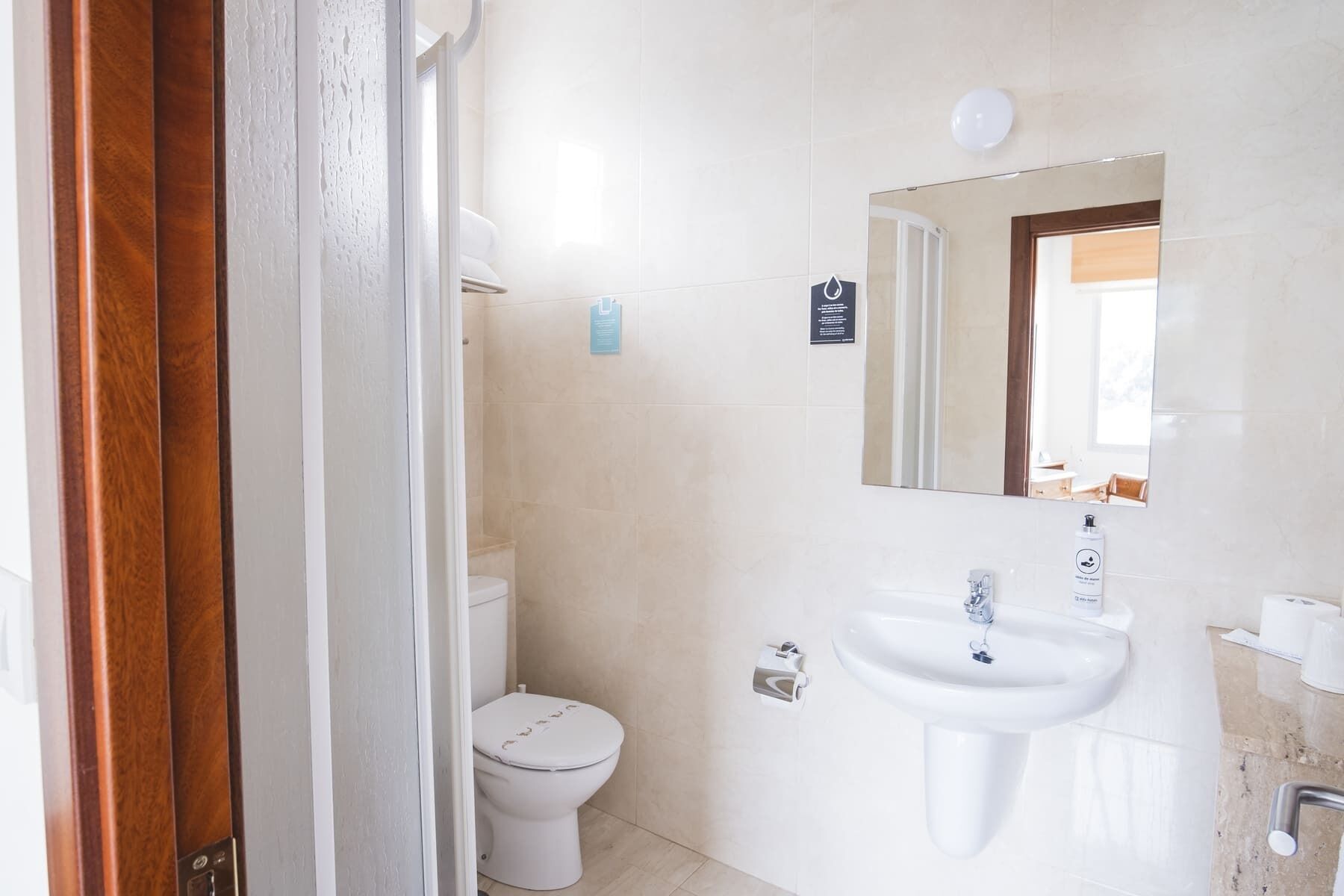 Une salle de bain avec des toilettes, un lavabo et un miroir.