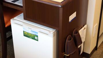 A refrigerator with a Toshiba sticker, a pair of brown slippers, and a white door handle.