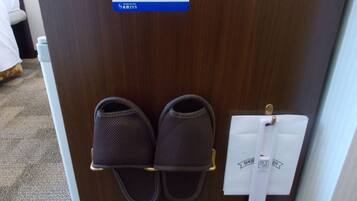 A pair of slippers on a shoe rack and a note on the door.