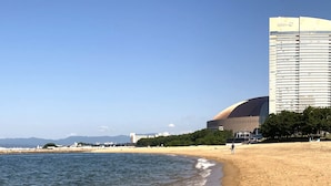 Vista sulla spiaggia con un grande albergo e uno stadio.