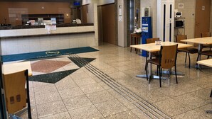 A hotel lobby with a reception desk, seating area, and a small kitchenette. - Toyoko Inn Osaka Temmabashi Otemae (Osaka)