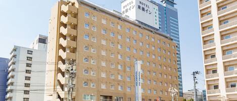 A multi-story hotel with a uniform facade, numerous windows, and a prominent vertical sign.
