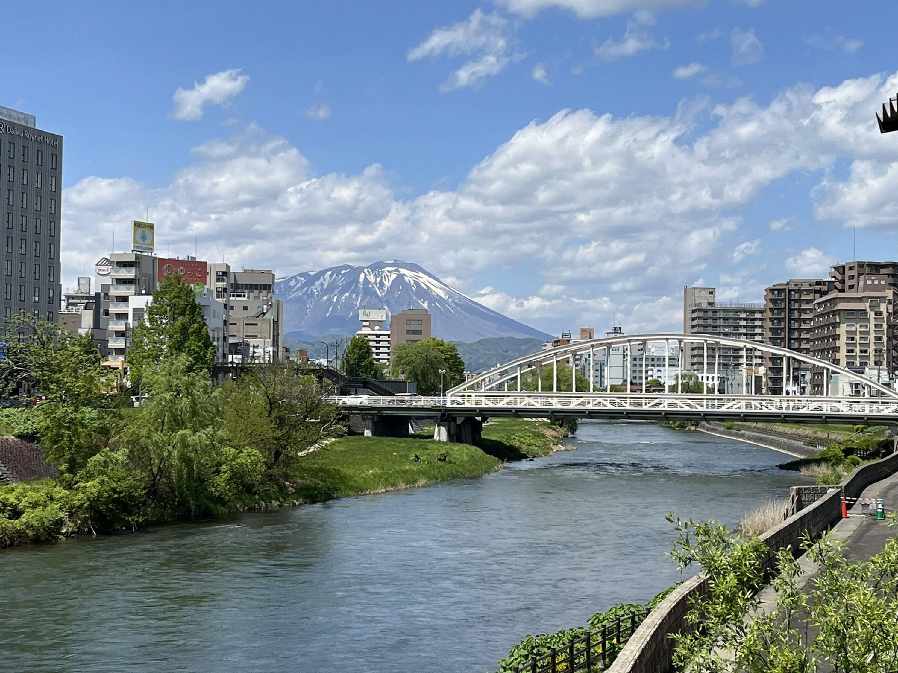 A bridge over a river with a mountain in the background.