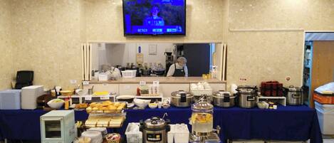 A buffet setup with various food items and kitchen equipment.