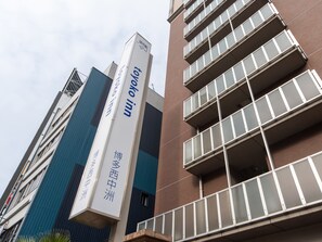 Un immeuble d’hôtel à plusieurs étages, doté de balcons avec des garde-corps en verre.