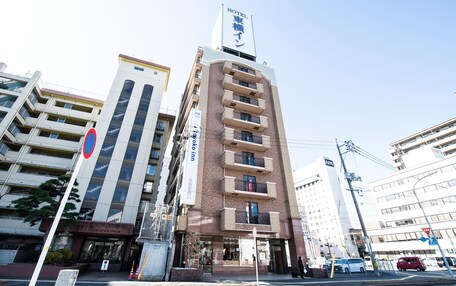A hotel with a prominent sign, multiple floors, and a modern architectural style.