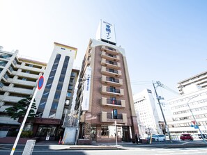 Un hotel con un letrero llamativo, varios pisos y un estilo arquitectónico moderno.