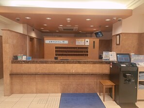 A reception desk with a computer monitor, a cash register, and a small table. - Toyoko Inn Osaka Hommachi No.1 (Osaka)