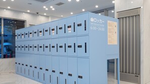 Egy sor kék színű, önkiszolgáló tárolószekrény, amelyen egy tábla jelzi a használati időt: 6:00–24:00.