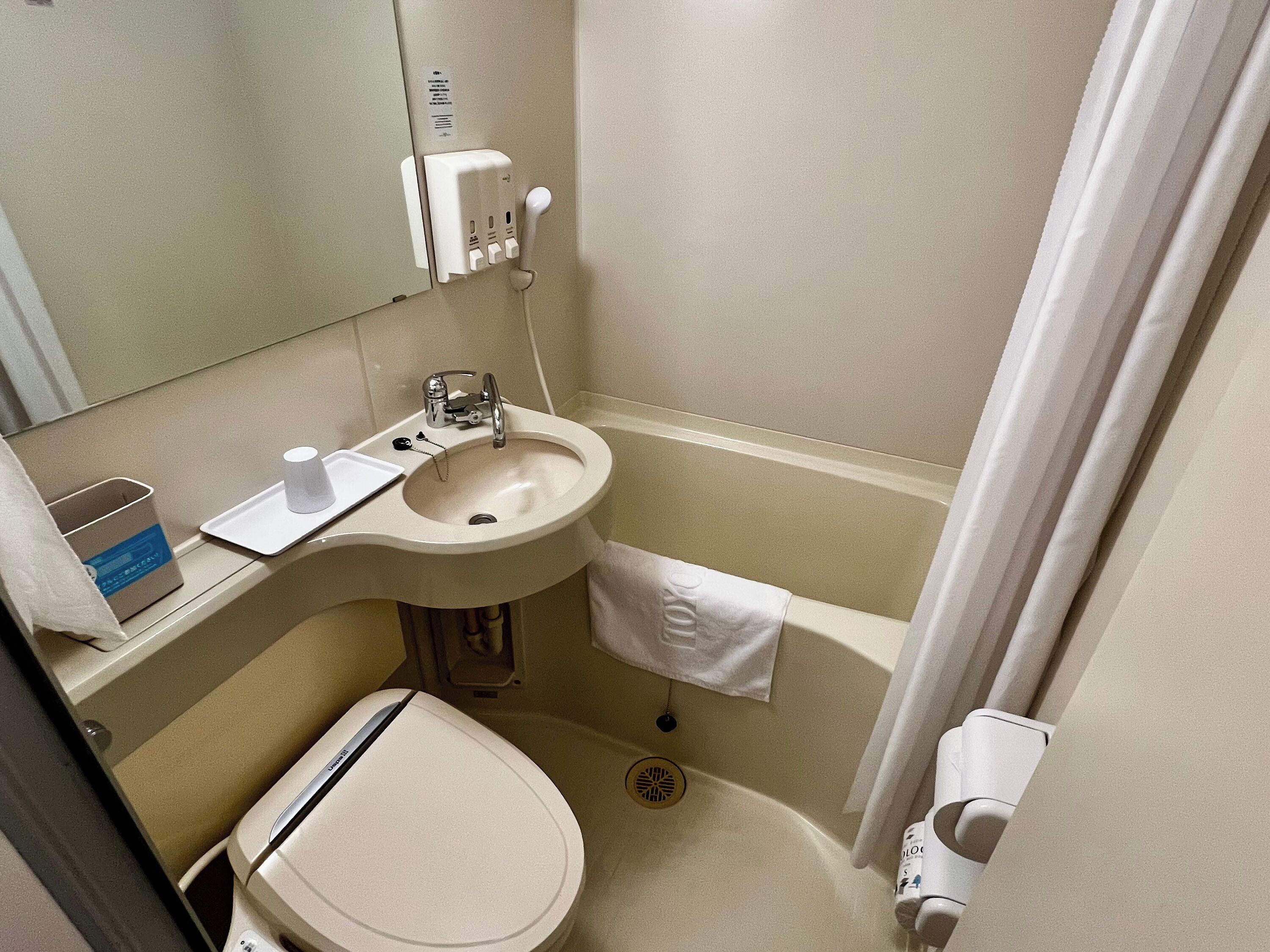 Ein kleines Badezimmer mit Toilette, Waschbecken und Dusche.