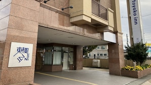 L'exterior d'un hotel amb un senyal prominent que diu "Toyoko Inn".