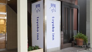 Entrada de un edificio con dos letreros verticales que indican "Toyoko Inn".