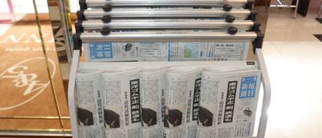 A display rack with magazines and a sign with Japanese text.