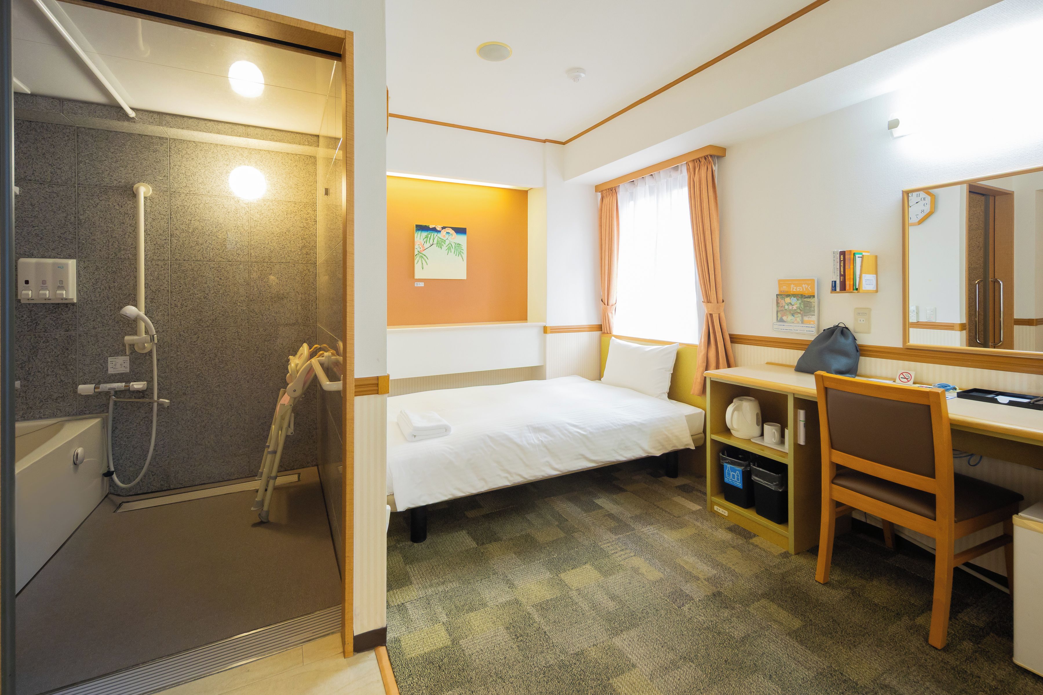 Ein Hotelzimmer mit Dusche, Bett, Schreibtisch und Spiegel.