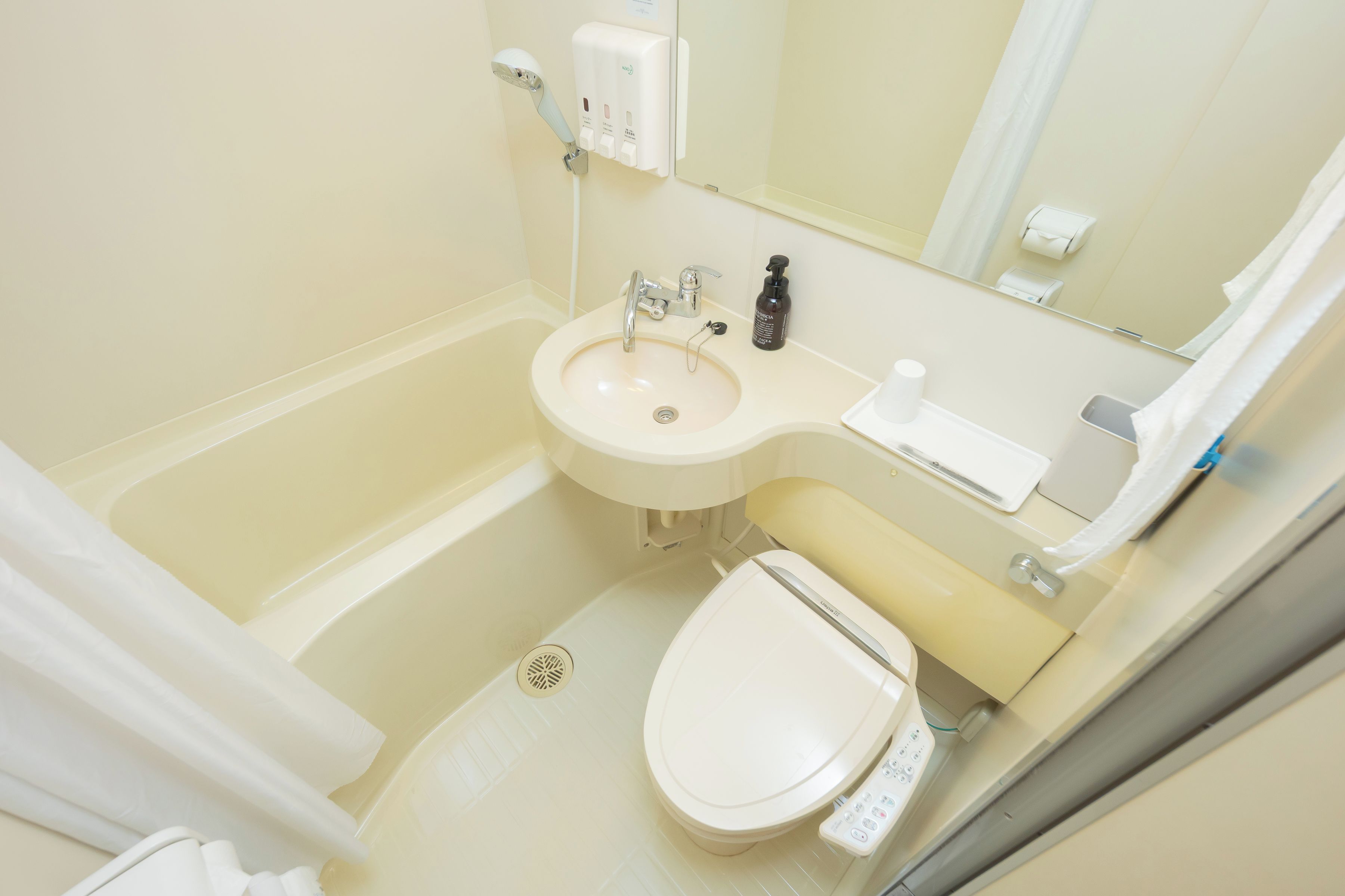A bathroom with a bathtub, a sink, a toilet, and a mirror.