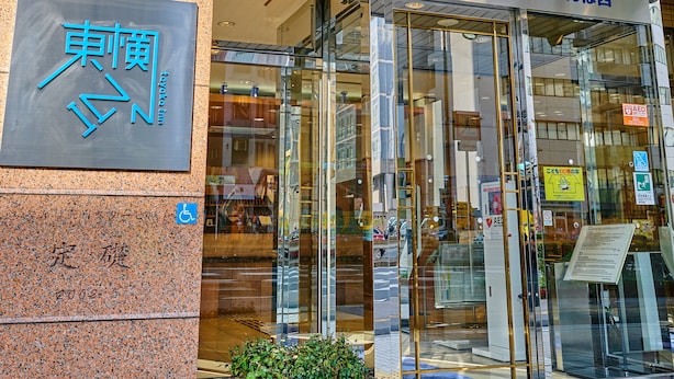 Entrada de un hotel con un cartel que dice "Toyako Inn" y otro cartel sobre la puerta que indica "Toyako Inn Kyoto".
