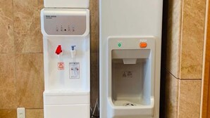 Un dispensador de agua con botón pulsador y un enfriador de agua con botón pulsador.