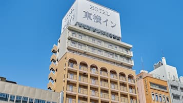 Un edificio de hotel con varios pisos, balcones y un cartel que indica que es un hotel.