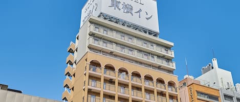 A hotel building with multiple floors, balconies, and a sign indicating it is a hotel.
