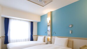 A hotel room with two beds, a window with curtains, a wall clock, and a thermostat.