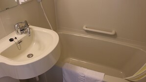 A bathroom with a white sink, a bathtub, and a towel hanging on the wall. - Toyoko Inn Utsunomiya Ekimae No.1 (Utsunomiya)